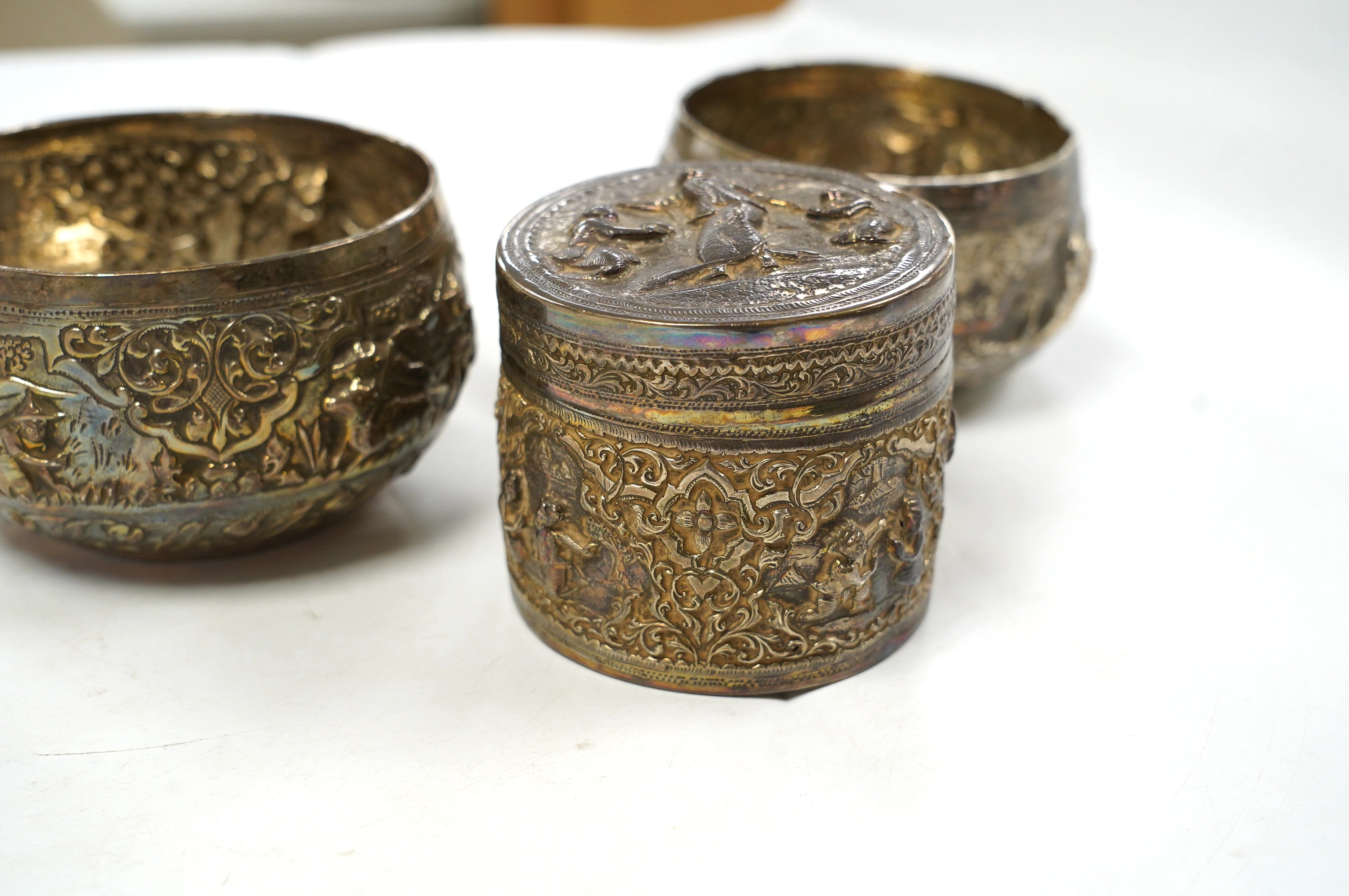 A pair of mid 20th century Indian embossed white metal small bowls, inscribed ' Agri-Horticultural Society Flower Show February 1953', diameter 10.4cm, together with a similar box and cover. Condition - poor to fair